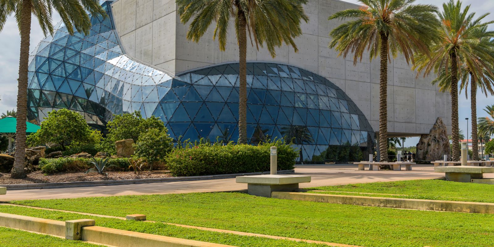 A Large Glass Building With Palm Trees