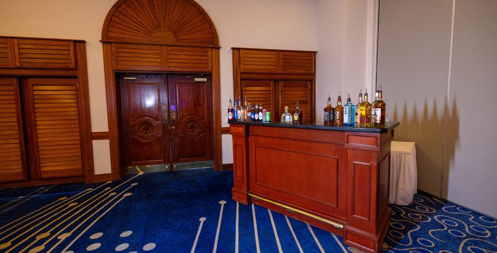 A Room With A Counter And A Door With Bottles On It